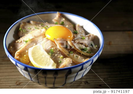カットレモンと卵黄が乗った熱々豚トロ丼、焼き肉丼 カットレモンと卵黄が乗った熱々豚トロ丼、焼き肉丼 91741197
