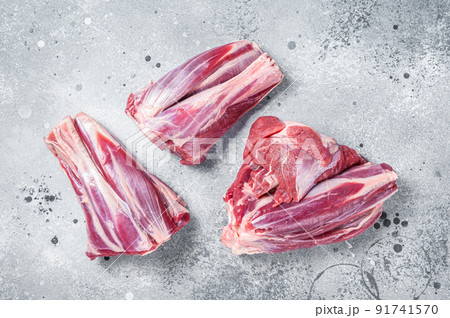 Uncooked Raw lamb shanks, mutton meat on kitchen table. Gray background. Top view Uncooked Raw lamb shanks, mutton meat on kitchen table. Gray background. Top view 91741570