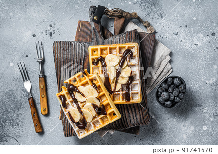 Traditional belgian waffles with fresh banana and Chocolate sauce . Gray background. Top view 91741670