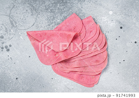 Thin slices of pork ham on a wooden kitchen table. Gray background. Top view 91741993