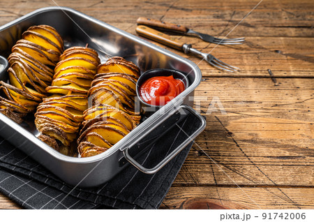 Skewered fried tornado or twist potatoes with ketchup sauce. Wooden background. Top view. Copy space 91742006