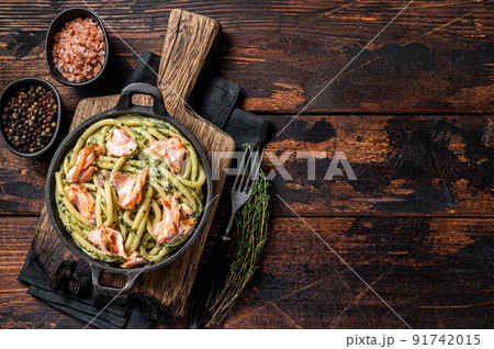 Salmon Bucatini pasta with creamy spinach sauce and fish fillet. Wooden background. Top view. Copy space Salmon Bucatini pasta with creamy spinach sauce and fish fillet. Wooden background. Top view. Copy space 91742015