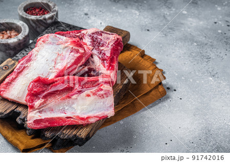 Beef veal short ribs kalbi, raw meat on wooden butcher board. Gray background. Top view. Copy space Beef veal short ribs kalbi, raw meat on wooden butcher board. Gray background. Top view. Copy space 91742016
