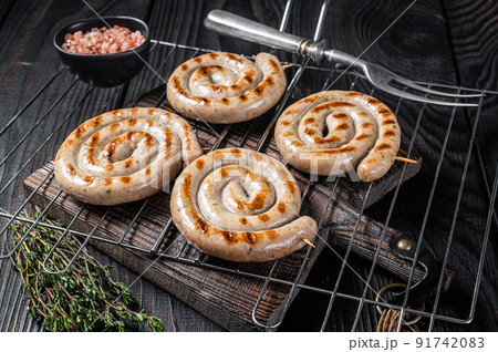 BBQ grilled spiral pork meat sausages on a grill. Black background. Top view BBQ grilled spiral pork meat sausages on a grill. Black background. Top view 91742083