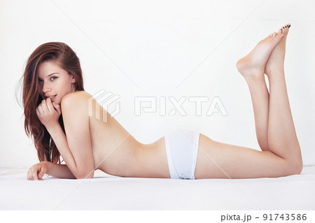 Absolute desire. Full-body portrait of a gorgeous young woman lying on her bed topless. Absolute desire. Full-body portrait of a gorgeous young woman lying on her bed topless. 91743586