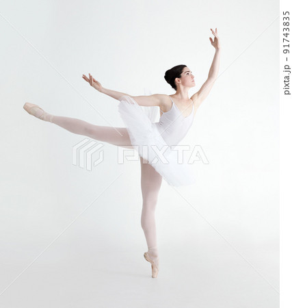 Perfect arabesque. Elegant young ballerina dancing en pointe against a white background. Perfect arabesque. Elegant young ballerina dancing en pointe against a white background. 91743835