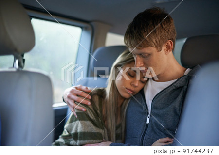Not long now. Shot of a tired young couple sitting together in the back seat of a car. Not long now. Shot of a tired young couple sitting together in the back seat of a car. 91744237