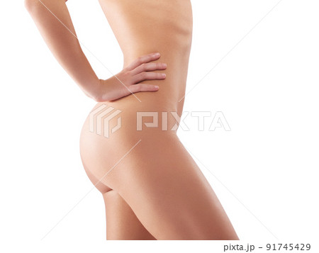 Owning her curves. Studio shot of a beautiful woman posing naked against a white background. 91745429