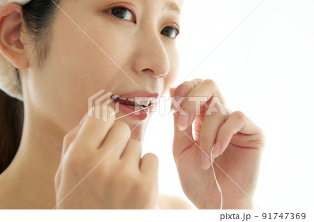 洗面所でデンタルフロスをする女性 洗面所でデンタルフロスをする女性 91747369