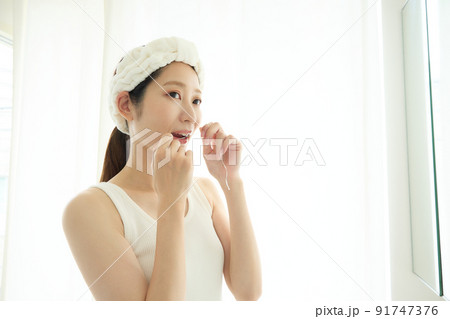 洗面所でデンタルフロスをする女性 91747376