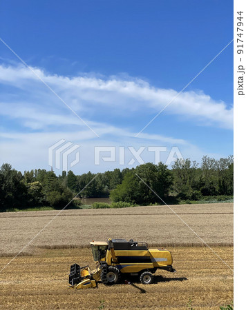 Combine harvester harvests ripe wheat, agriculture, France Combine harvester harvests ripe wheat, agriculture, France 91747944