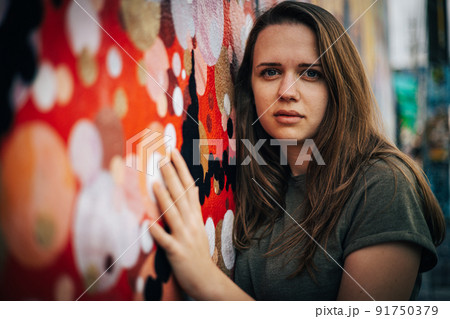 Beautiful female street fashion model poses for the camera in the colorful streets of Miami 91750379