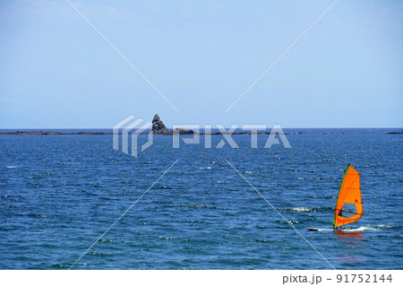 初夏の茅ヶ崎海岸 エボシ岩とウィンドサーフィンの写真素材 [91752144