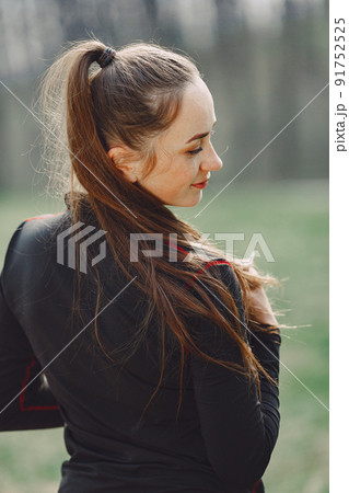 Woman in a black sportswear. Girl in a spring park. Woman in a black sportswear. Girl in a spring park. 91752525