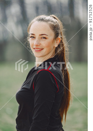 Woman in a black sportswear. Girl in a spring park. Woman in a black sportswear. Girl in a spring park. 91752526