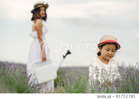 Mother with little daughter on lavender background. Beautiful woman and cute baby playing in meadow field. Family holiday in summer day. Mother with little daughter on lavender background. Beautiful woman and cute baby playing in meadow field. Family holiday in summer day. 91752785