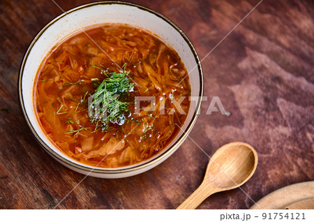 Ukrainian Borscht served in a bowl with dill and parsley on rustic wooden table. Ukrainian and Russian national cuisine. Ukrainian Borscht served in a bowl with dill and parsley on rustic wooden table. Ukrainian and Russian national cuisine. 91754121