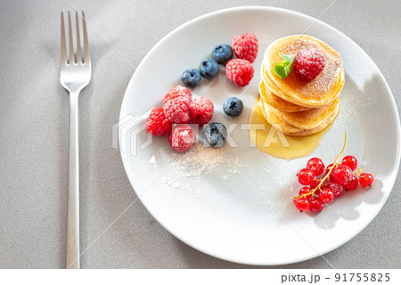 Food for breakfast healthy eating. Pancakes without butter with berries. Food for vegetarians and for dieting. American Pancakes Mini. Mini pancakes with blueberries and raspberries. American Food for breakfast healthy eating. Pancakes without butter with berries. Food for vegetarians and for dieting. American Pancakes Mini. Mini pancakes with blueberries and raspberries. American 91755825