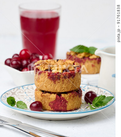 Portioned cherry crumble pie on a plate, white background 91761838