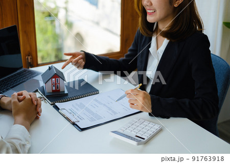 Guarantee, mortgage, agreement, contract, signed, real estate agent pointing to documents for customers to read the agreement before signing important documents. Guarantee, mortgage, agreement, contract, signed, real estate agent pointing to documents for customers to read the agreement before signing important documents. 91763918