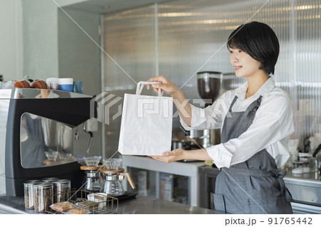 カフェ 商品を渡す女性スタッフ カフェ 商品を渡す女性スタッフ 91765442