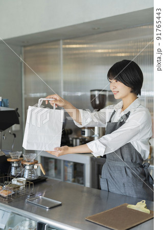 カフェ 商品を渡す女性スタッフ カフェ 商品を渡す女性スタッフ 91765443