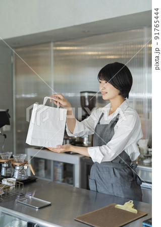 カフェ 商品を渡す女性スタッフ 91765444