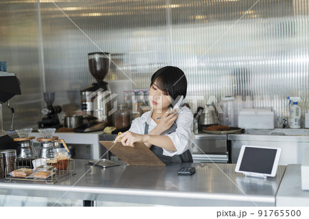 カフェ 電話をする女性スタッフ 91765500