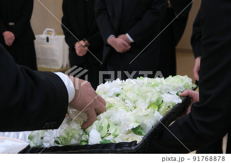 お棺にお花を手向ける親族 91768878