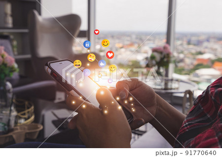 Young man using smartphone sending emojis. Mobile smartphone sending text messages emoji emoticon. 91770640