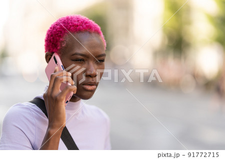 Afro woman with a distrustful expression talking on a mobile 91772715
