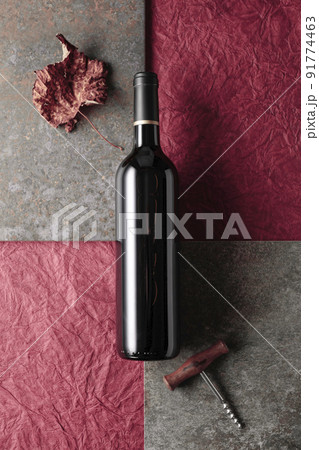 Bottle of red wine with old corkscrew. 91774463