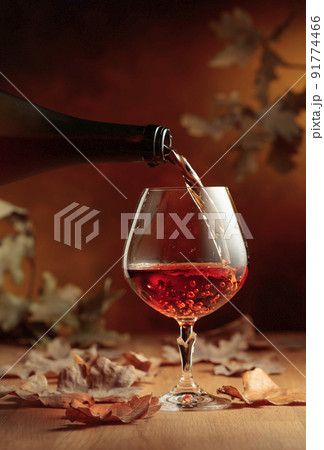 Cognac is poured into a glass from a bottle. 91774466
