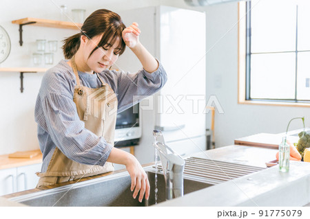 キッチンで後片付けをする女性(疲労) キッチンで後片付けをする女性(疲労) 91775079