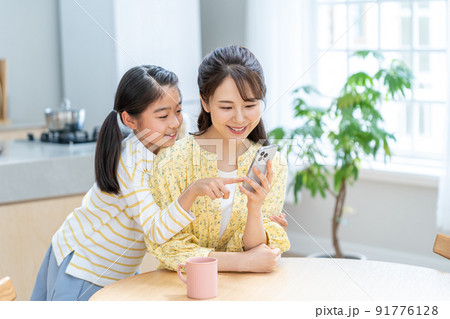 スマホを操作する親子 91776128