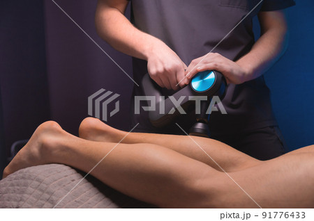 Rehabilitation. Massage therapist performs prophylactic percussive massage Rehabilitation. Massage therapist performs prophylactic percussive massage 91776433