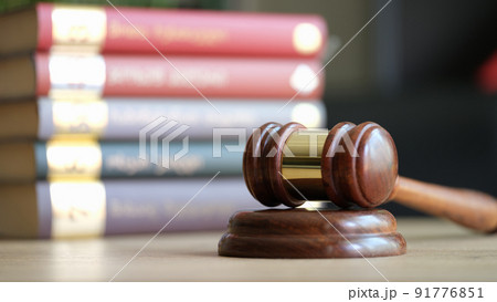Judge gavel or hammer on sounding block and stack of law books 91776851