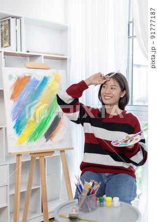Female artist painting on canvas, Artist studio interior, Draw with watercolor, Drawing supplies , Painting and creativity, Use a brush to draw a pattern by stripes, Artwork, Using Paint Brush. 91777187