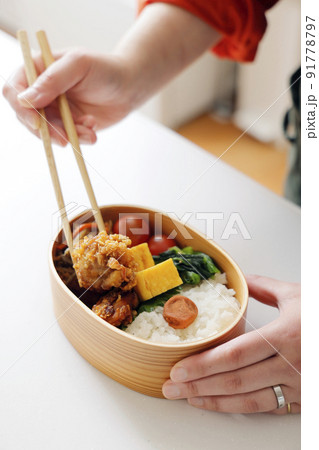 お母さんがキッチンでお弁当を作るシーン 91778797