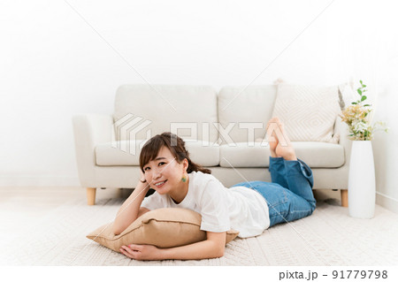 家のリビングでリラックスする日本人女性（くつろぐ） 91779798