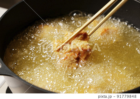 油で揚げている美味しそうな鶏の唐揚げ 油で揚げている美味しそうな鶏の唐揚げ 91779848