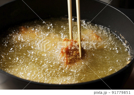 油で揚げている美味しそうな鶏の唐揚げ 91779851