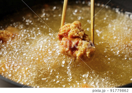 油で揚げている美味しそうな鶏の唐揚げ 油で揚げている美味しそうな鶏の唐揚げ 91779862