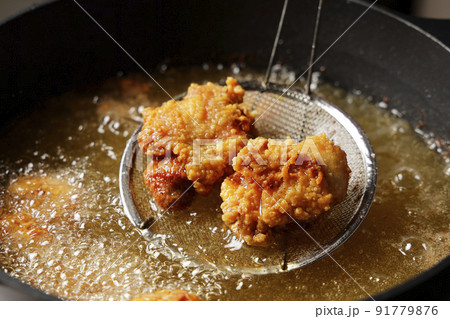油で揚げている美味しそうな鶏の唐揚げ 91779876