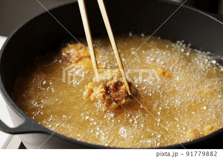 油で揚げている美味しそうな鶏の唐揚げ 91779882