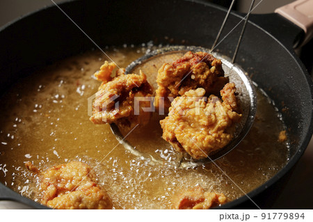 油で揚げている美味しそうな鶏の唐揚げ 油で揚げている美味しそうな鶏の唐揚げ 91779894