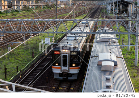 【関西線】夕暮れ時の車庫横を通過する列車 91780745