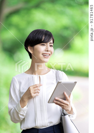 屋外でタブレットを操作するビジネスウーマン タブレットを使う若い女性 屋外でタブレットを操作するビジネスウーマン タブレットを使う若い女性 91781465