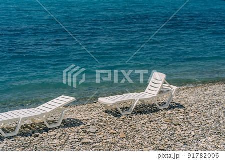 Pair of sun loungers at pebble beach, perfect vacation. Pair of sun loungers at pebble beach, perfect vacation. 91782006