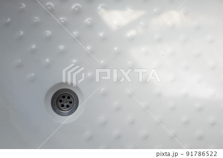 The drain in the white plastic shower 91786522
